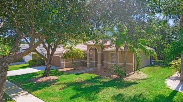 761 Grand Rapids Blvd, Naples, FL 34120 - view of front of property featuring driveway, stucco siding, a front yard, a garage, and a tile roof