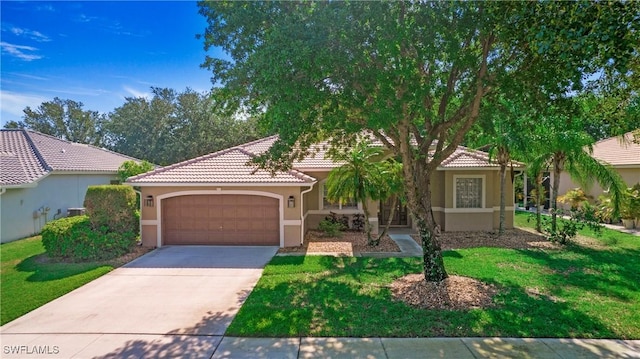 761 Grand Rapids Blvd, Naples, FL 34120 - view of front of home with a garage, stucco siding, concrete driveway, a tile roof, and a front yard
