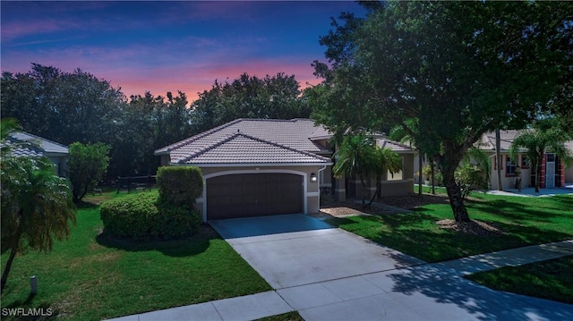761 Grand Rapids Blvd, Naples, FL 34120 - mediterranean / spanish-style house featuring a garage, a lawn, driveway, and a tile roof