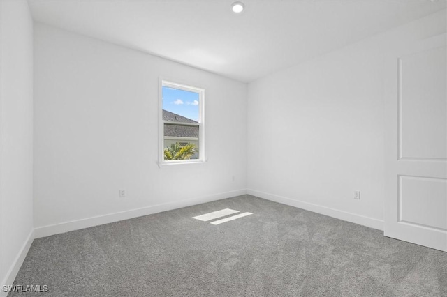 empty room featuring carpet and baseboards