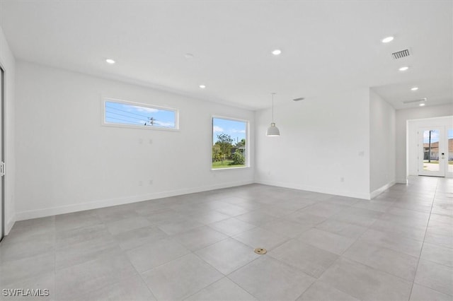 empty room featuring recessed lighting, visible vents, and a wealth of natural light