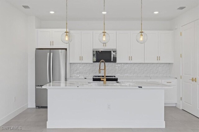 kitchen with a center island with sink, visible vents, backsplash, white cabinets, and appliances with stainless steel finishes
