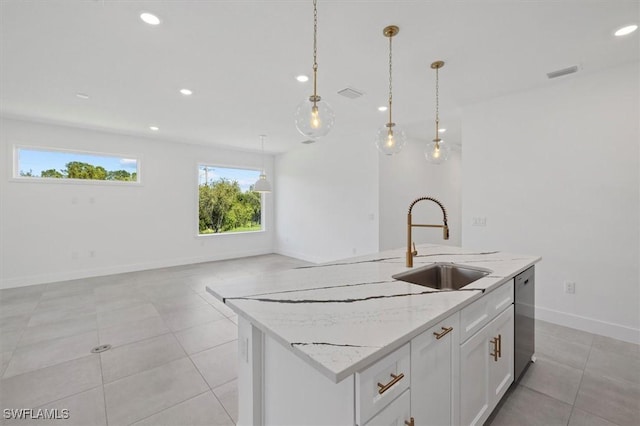 kitchen with an island with sink, stainless steel dishwasher, a sink, white cabinetry, and visible vents