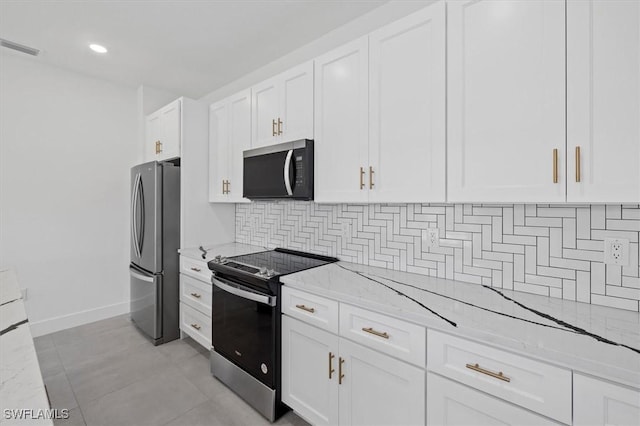 kitchen with tasteful backsplash, light stone countertops, stainless steel appliances, and white cabinets