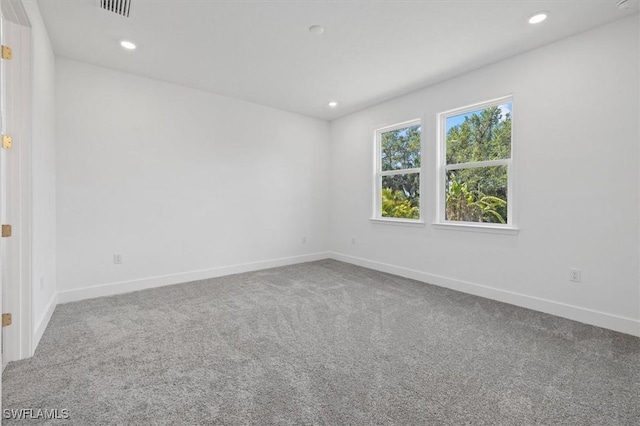 spare room featuring recessed lighting and baseboards