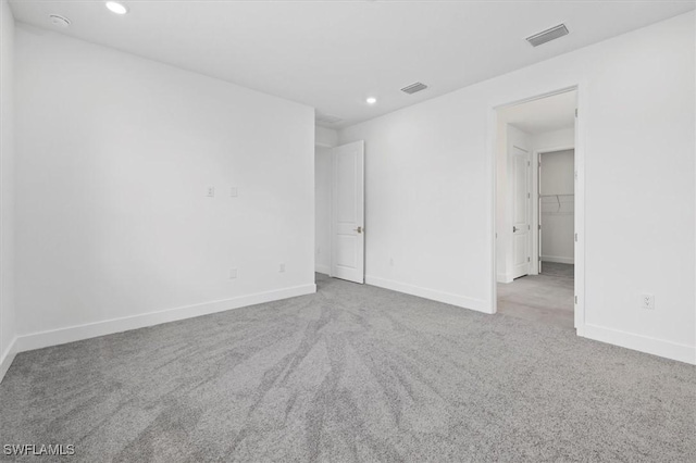 empty room featuring baseboards, visible vents, carpet flooring, and recessed lighting