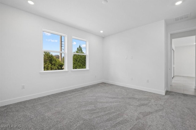 carpeted empty room featuring visible vents, recessed lighting, and baseboards