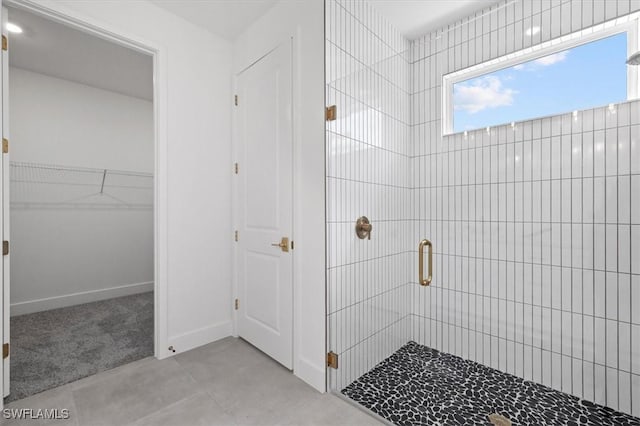 bathroom with a spacious closet and a stall shower