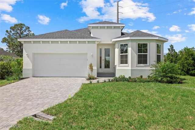 prairie-style house featuring stucco siding, decorative driveway, roof with shingles, a front lawn, and an attached garage