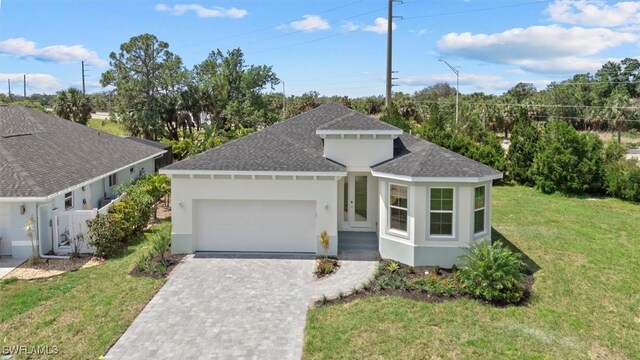 view of front of property featuring a front lawn, a shingled roof, stucco siding, decorative driveway, and an attached garage