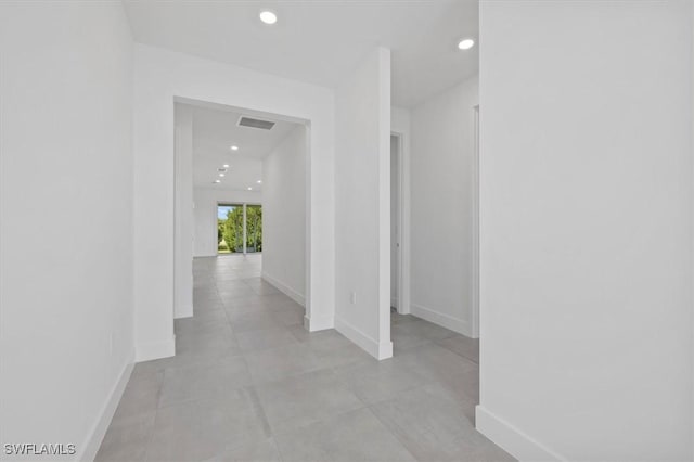 corridor with baseboards, recessed lighting, and visible vents