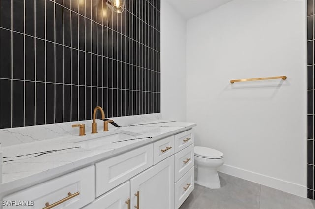 bathroom featuring baseboards, toilet, tile patterned flooring, and vanity