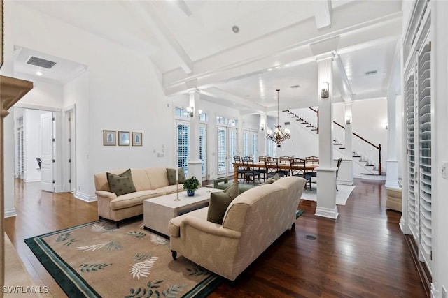 living room with dark wood finished floors, baseboards, decorative columns, visible vents, and stairway