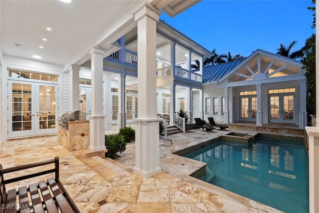 rear view of house featuring exterior kitchen, french doors, an outdoor pool, and a patio area