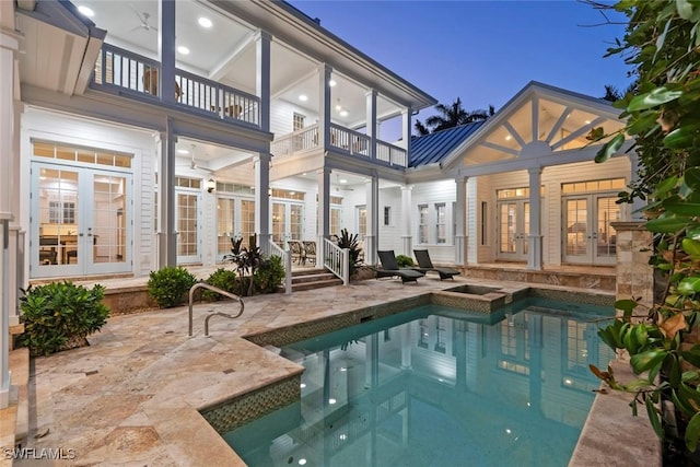 rear view of house featuring a patio, metal roof, french doors, and a balcony