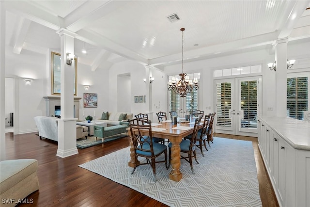 dining space featuring visible vents, decorative columns, wood finished floors, beamed ceiling, and french doors