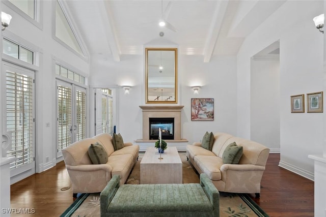 living room with a glass covered fireplace, baseboards, lofted ceiling with beams, and wood finished floors