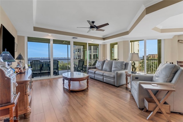 15140 Harbour Isle Dr Unit 502, Fort Myers, FL 33908 - living room with a raised ceiling, a ceiling fan, crown molding, and wood finished floors