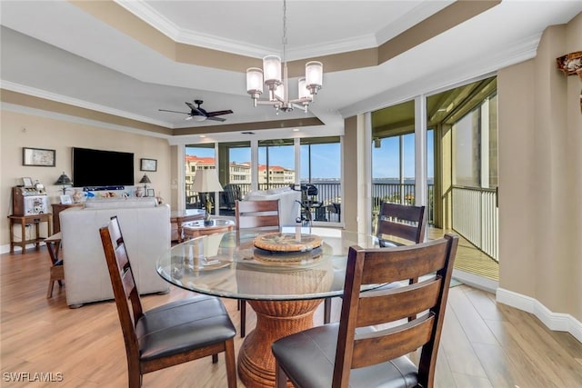 15140 Harbour Isle Dr Unit 502, Fort Myers, FL 33908 - dining area with a raised ceiling, a ceiling fan, a chandelier, light wood-type flooring, and crown molding