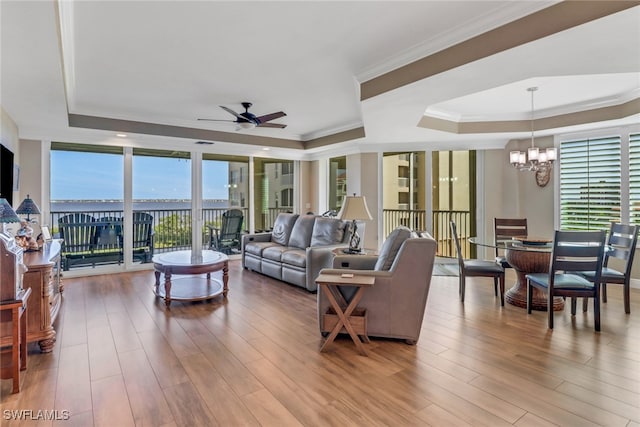 15140 Harbour Isle Dr Unit 502, Fort Myers, FL 33908 - living room featuring a tray ceiling, ceiling fan, a chandelier, wood finished floors, and ornamental molding