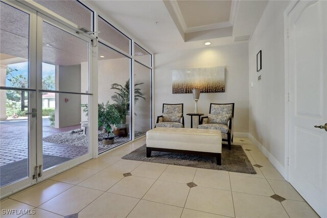 15140 Harbour Isle Dr Unit 502, Fort Myers, FL 33908 - sitting room with light tile patterned floors, crown molding, a tray ceiling, baseboards, and french doors