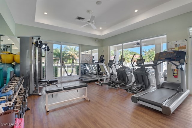 15140 Harbour Isle Dr Unit 502, Fort Myers, FL 33908 - exercise room featuring a ceiling fan, a tray ceiling, wood finished floors, and recessed lighting