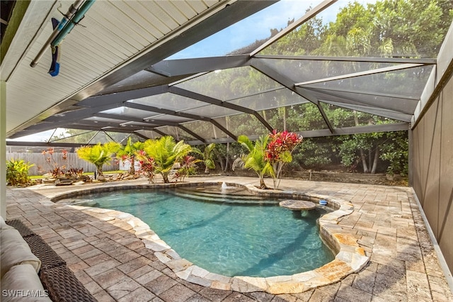 view of swimming pool with a fenced backyard, a fenced in pool, glass enclosure, and a patio area