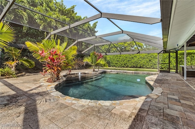outdoor pool featuring glass enclosure and a patio area