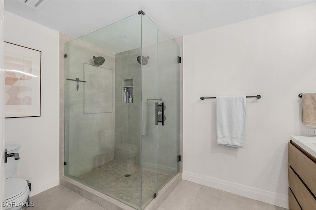 bathroom featuring toilet, vanity, a shower stall, and tile patterned floors