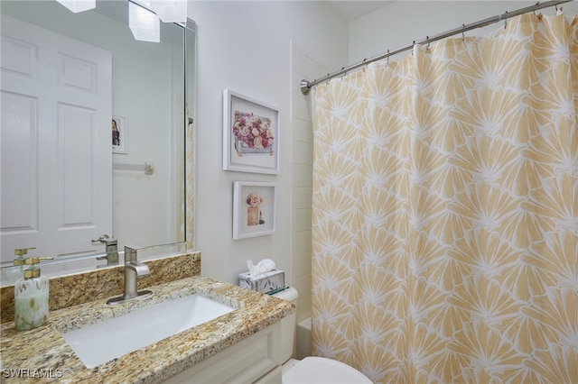 bathroom featuring vanity, shower / bath combo with shower curtain, and toilet