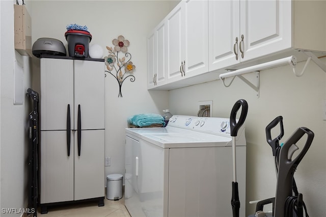 laundry area with washer / dryer, light tile patterned floors, and cabinet space