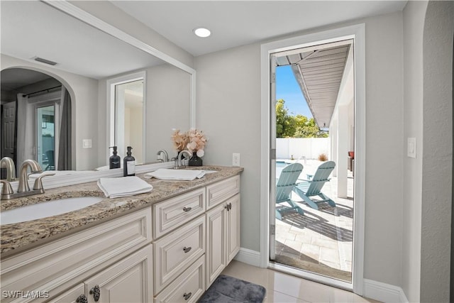 828 SW 51st Ter, Cape Coral, FL 33914 - bathroom with double vanity, a sink, tile patterned floors, and visible vents