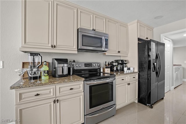 828 SW 51st Ter, Cape Coral, FL 33914 - kitchen featuring light tile patterned floors, stainless steel appliances, washing machine and clothes dryer, and light stone counters