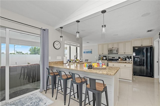 828 SW 51st Ter, Cape Coral, FL 33914 - kitchen featuring cream cabinetry, a kitchen breakfast bar, a sink, and appliances with stainless steel finishes