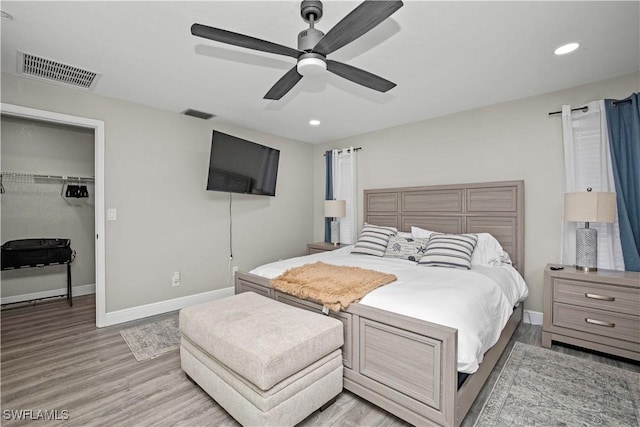 828 SW 51st Ter, Cape Coral, FL 33914 - bedroom featuring a walk in closet, visible vents, light wood finished floors, and baseboards