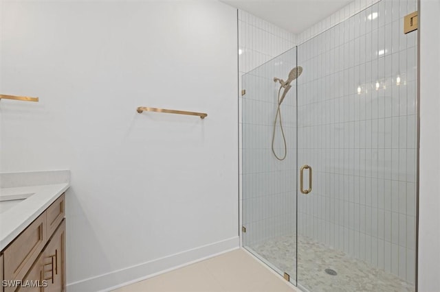 full bath featuring baseboards, a stall shower, and vanity
