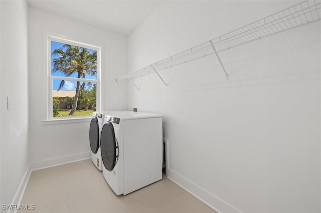washroom featuring independent washer and dryer, laundry area, and baseboards