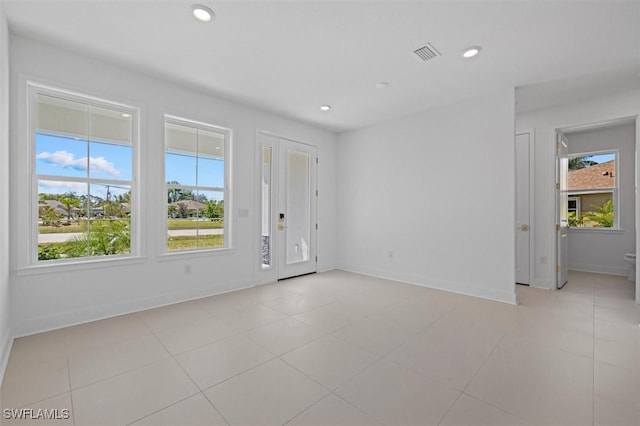 empty room featuring a healthy amount of sunlight, recessed lighting, and visible vents
