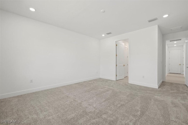 spare room with light colored carpet, visible vents, recessed lighting, and baseboards