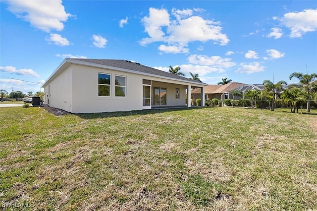 back of property featuring stucco siding and a lawn