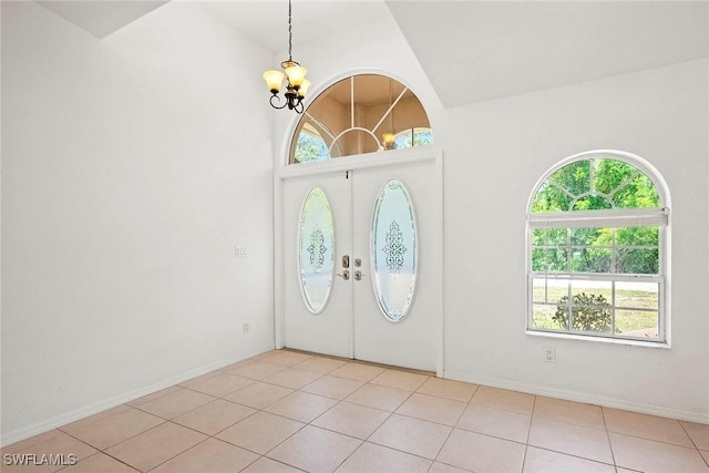 entrance foyer with light tile patterned flooring, an inviting chandelier, and a wealth of natural light