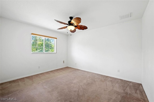 spare room with visible vents, a ceiling fan, carpet flooring, and baseboards