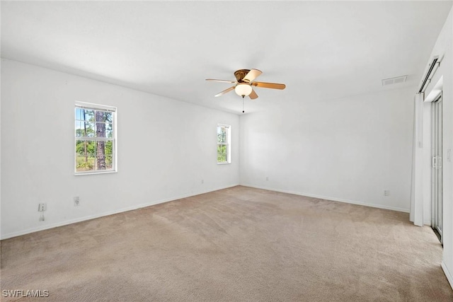 unfurnished bedroom with visible vents, multiple windows, and light colored carpet