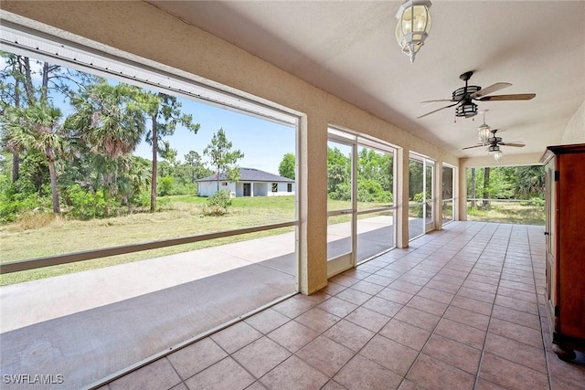 unfurnished sunroom with ceiling fan