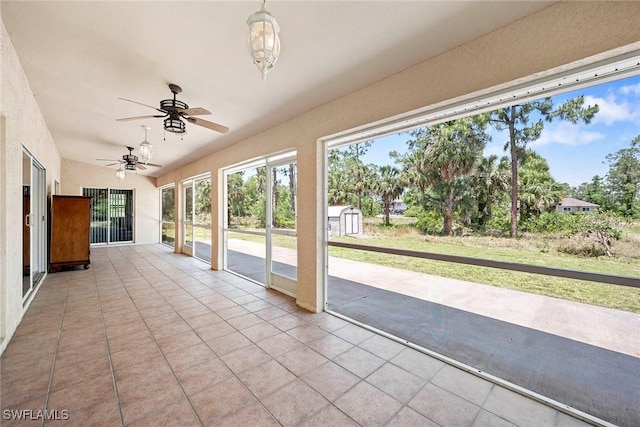 unfurnished sunroom with a ceiling fan