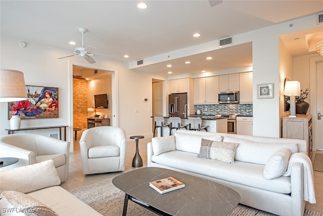 living room with visible vents, a ceiling fan, and recessed lighting