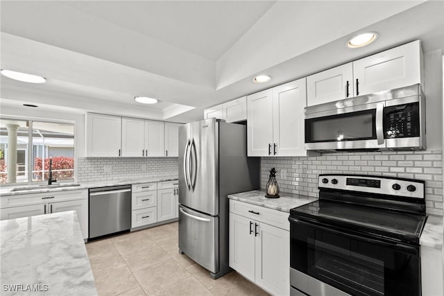 kitchen with a sink, white cabinetry, appliances with stainless steel finishes, and light stone countertops