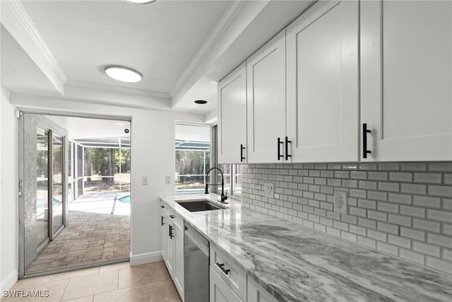 kitchen with a sink, light stone counters, tasteful backsplash, and dishwasher