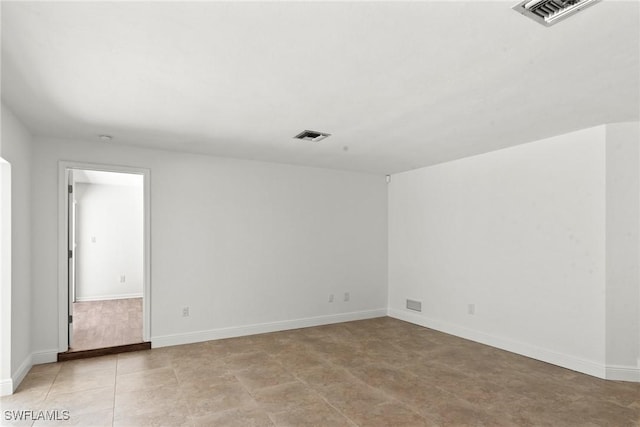 unfurnished room featuring baseboards and visible vents