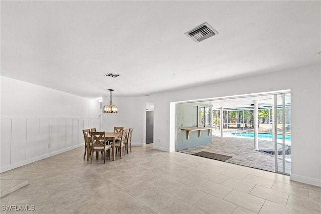 dining area with visible vents, wainscoting, and a notable chandelier